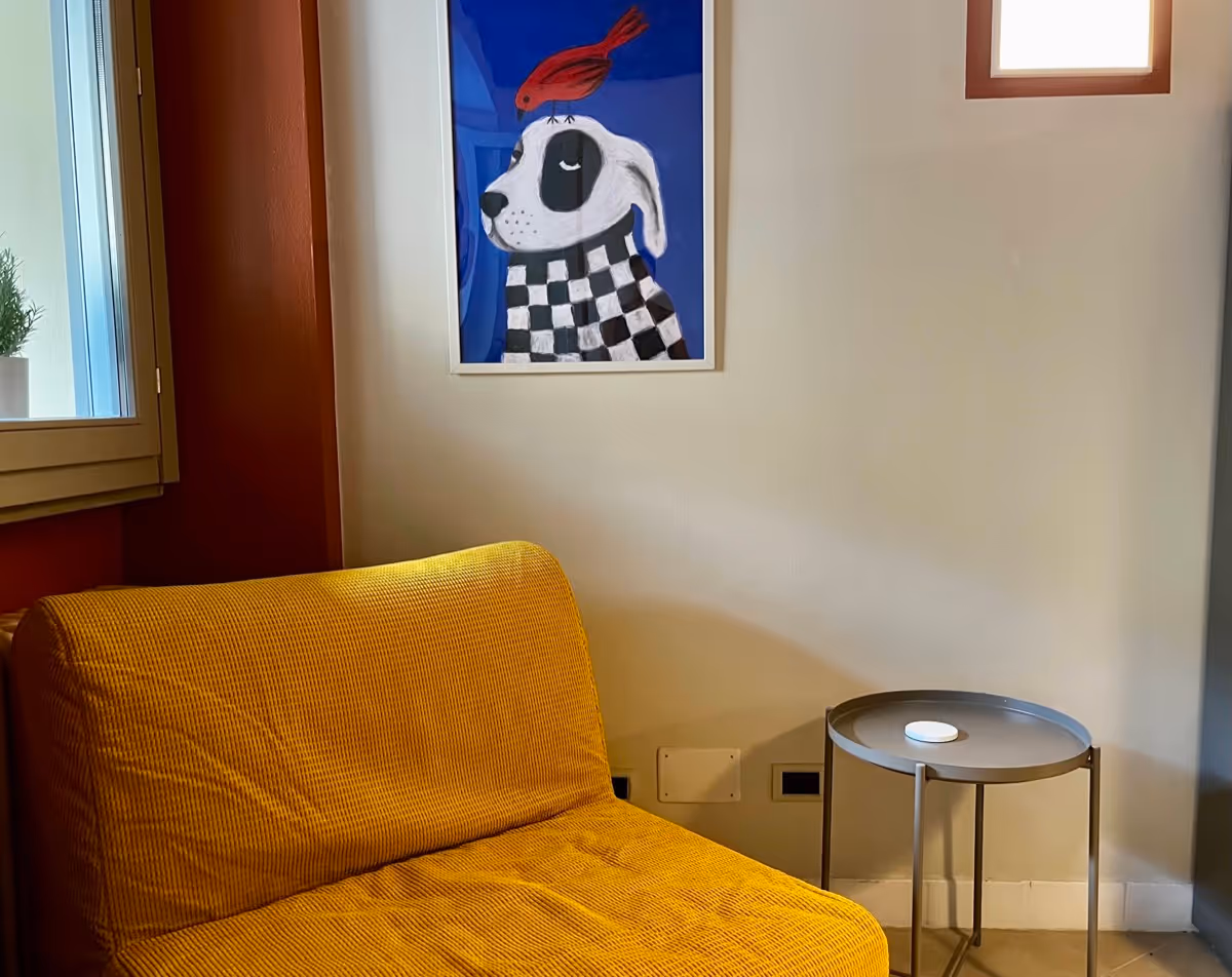 Angolo relax del soggiorno con poltrona letto gialla e luce naturale