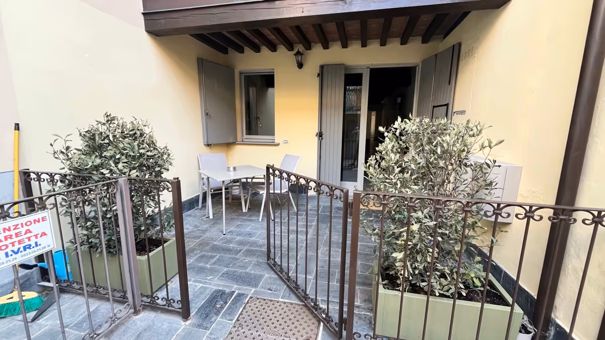 Patio privato arredato con tavolo e sedie sul tranquillo cortile interno