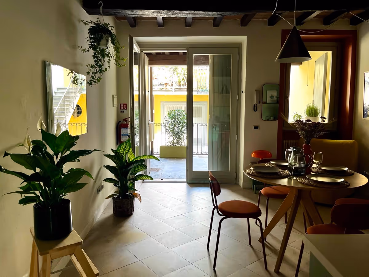 Soggiorno luminoso con grande porta-finestra che si apre sul patio privato