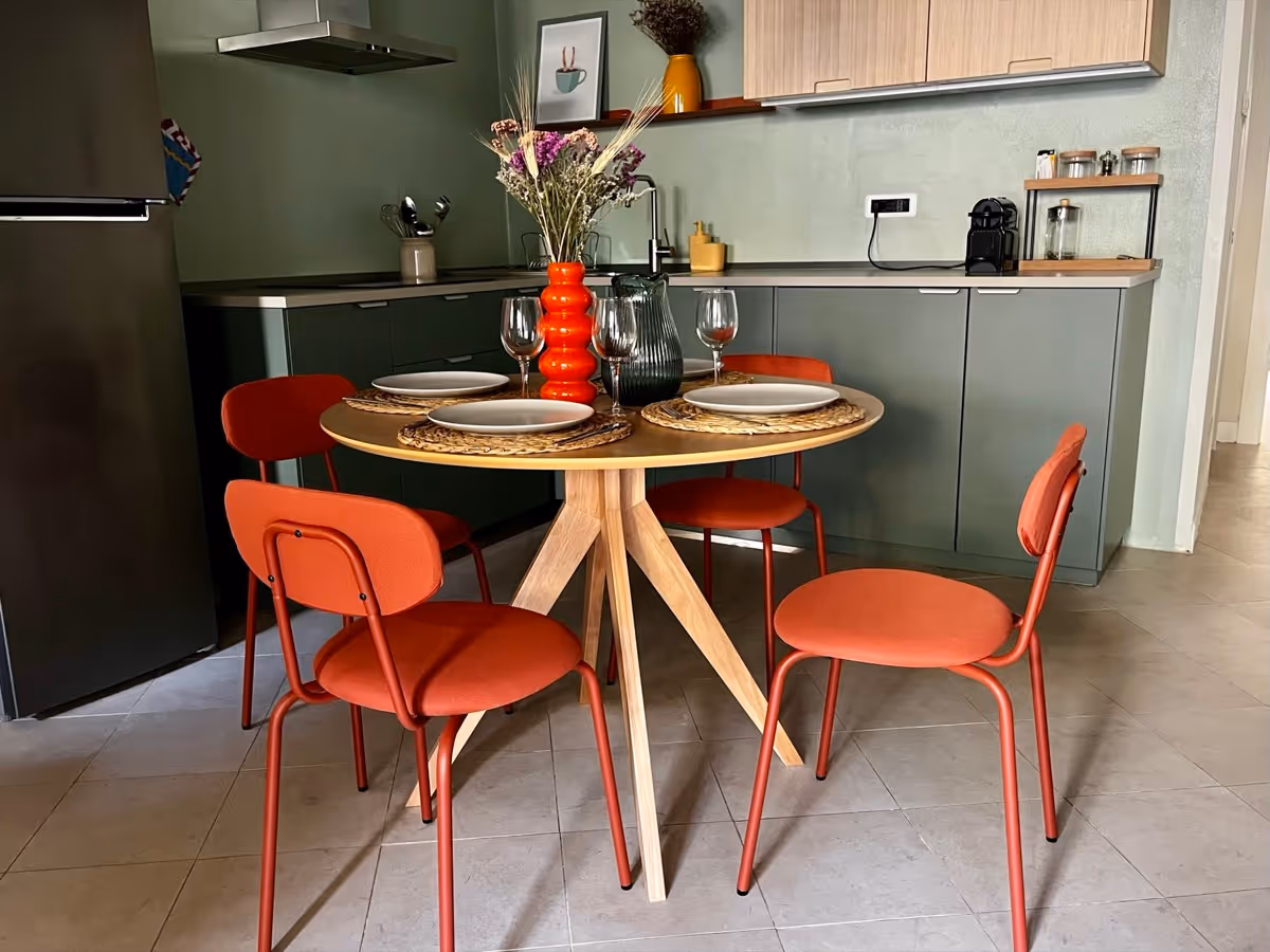 Dettaglio della cucina con piano a induzione e tavolo da pranzo apparecchiato