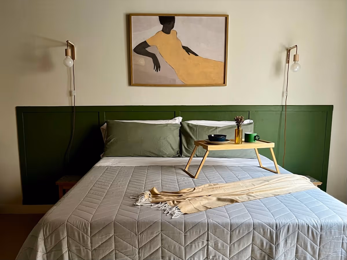 Letto matrimoniale con testiera verde e vassoio per la colazione
